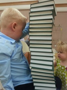 kids stacking hymnbooks in church