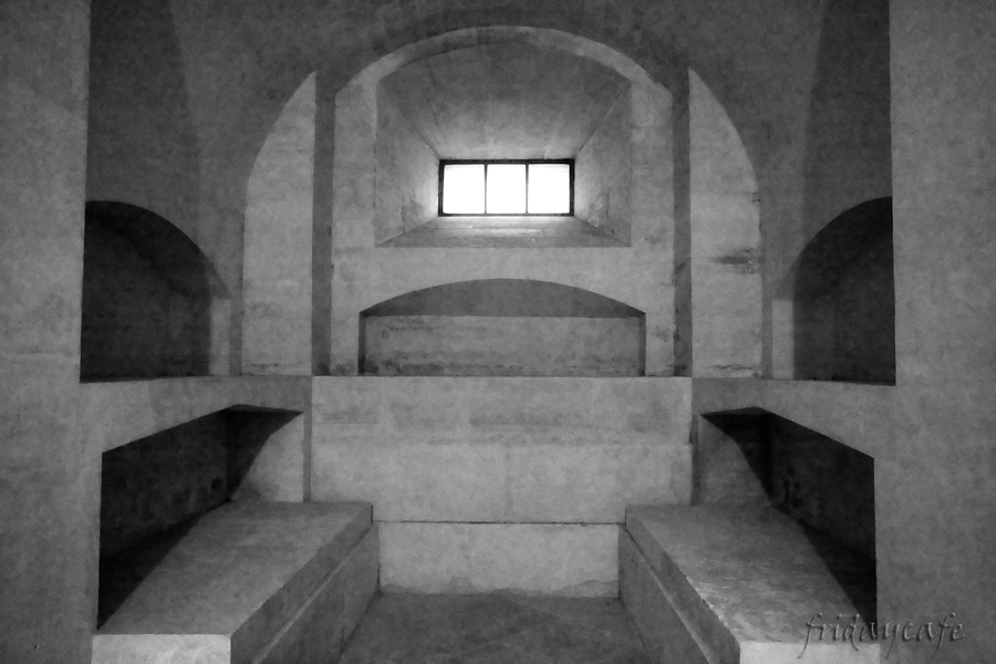 This photo shows an empty tomb in the Pantheon, with a window in the center and four empty shelves.