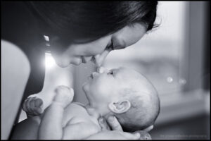 Mother touches noses with her new baby