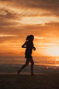 silhouette of woman running on the beach