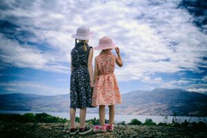 Two girls looking across a lake at a mountain