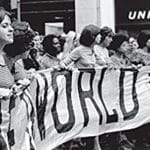 Image of women in Boston in the 1970s holding a banner with the word "world" visible.