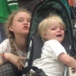 crying kid in stroller with big sister