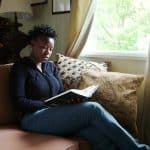 Woman studying a book with light from a window