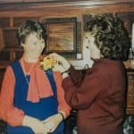 Exponent II founding mother Carrell Sheldon pins a boutonniere on Lavina Fielding Anderson