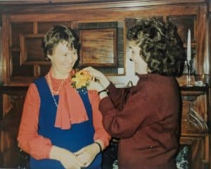 Exponent II founding mother Carrell Sheldon pins a boutonniere on Lavina Fielding Anderson