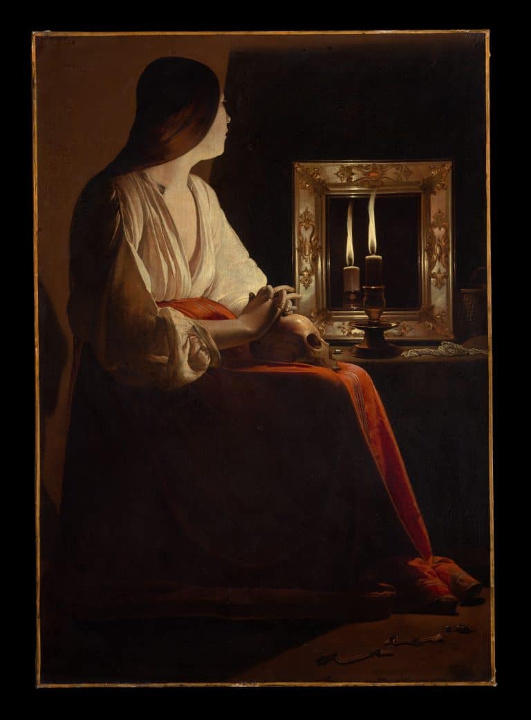 woman sitting in front of mirror