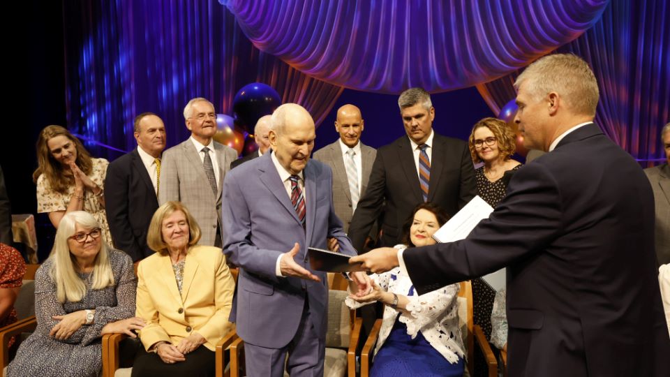 Russell M. Nelson receiving gifts at his 100 birthday celebration. This event was an example of benevolent sexism.