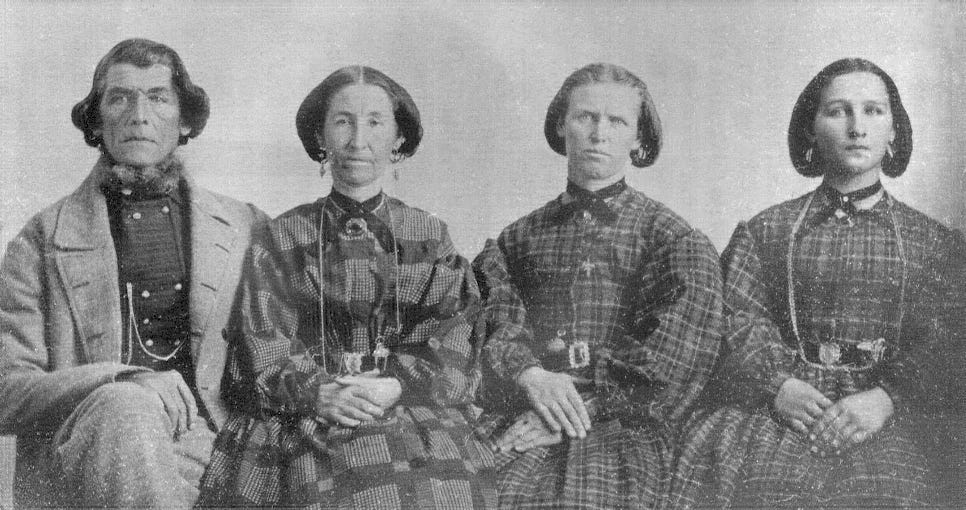 Black and white photo of a man with his three wives