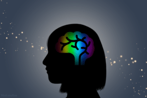 A dark background with a silhouette of a woman with short hair in the center. Her brain is lit up with rainbow colors, demonstrating neurodivergence.